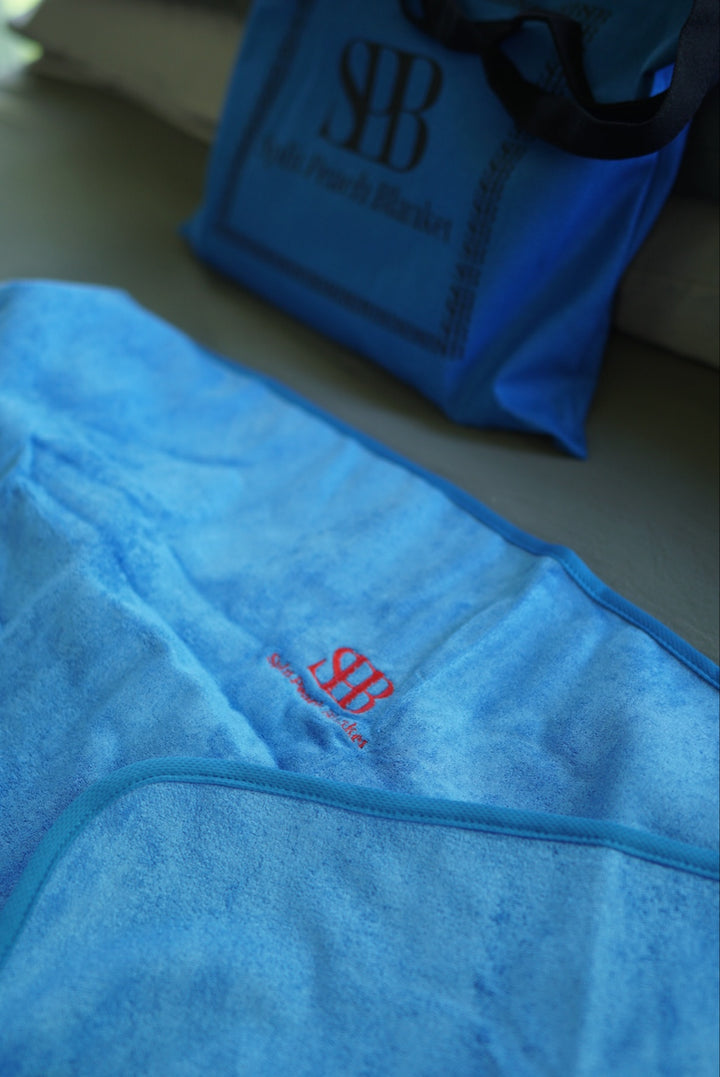 Close-up of Capri Blue Regular blanket fabric, edging and embroidered logo