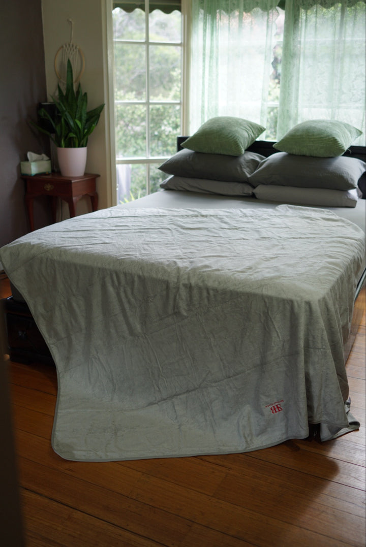 Crystal Luxury 200 × 200 cm bamboo and cotton waterproof blanket draped over a bed