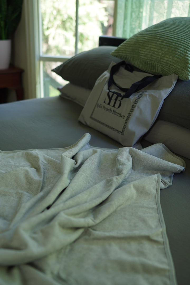 Crystal Regular waterproof blanket showing soft drape beside storage bag