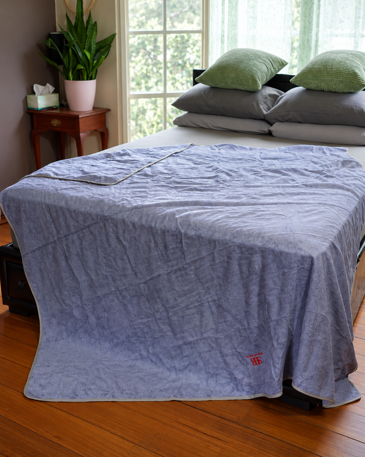 Sterling Lavender Luxury 200 × 200 cm bamboo and cotton waterproof blanket draped over a bed