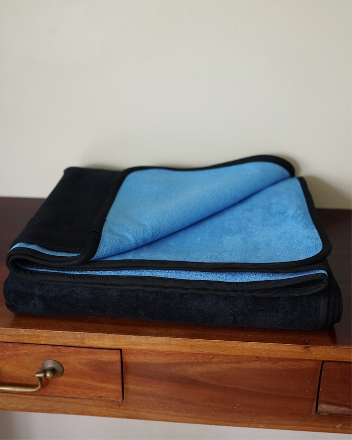 Folded Split Peach bamboo and cotton waterproof blanket showing black and blue sides